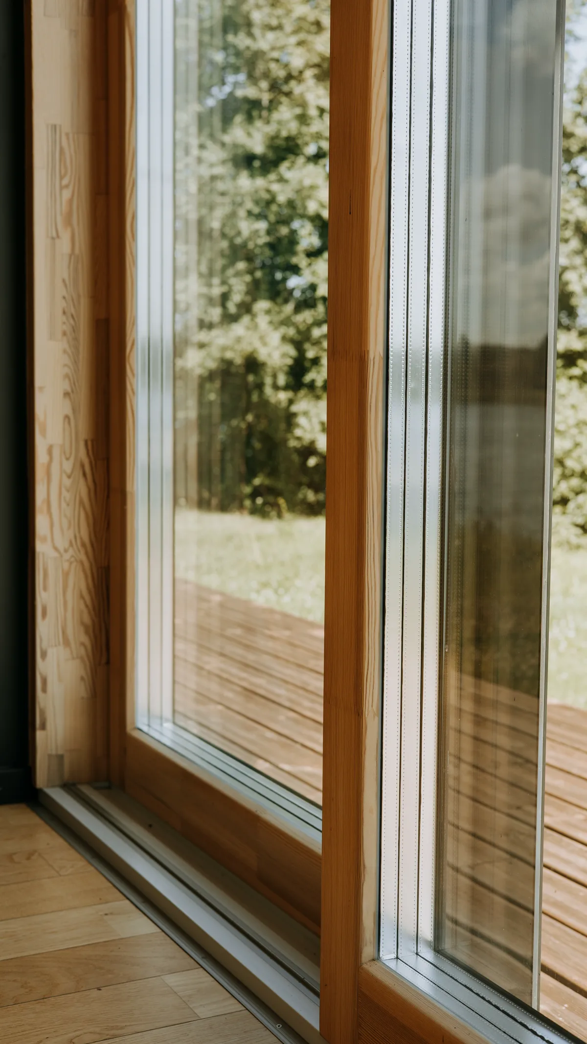 Крупный план рамы раздвижной деревянной двери с тройным остеклением и текстурой сосны