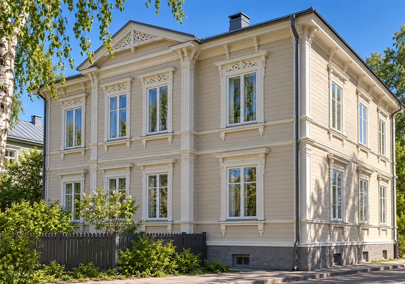 Kastenfenster aus Holz in den tiefen Laibungen einer historischen Stadthausfassade